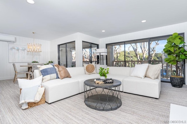 living room with a wall unit AC and an inviting chandelier