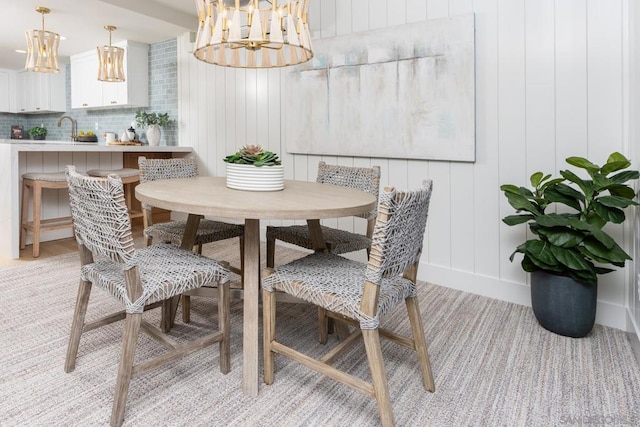 dining area featuring a notable chandelier, light hardwood / wood-style floors, and sink