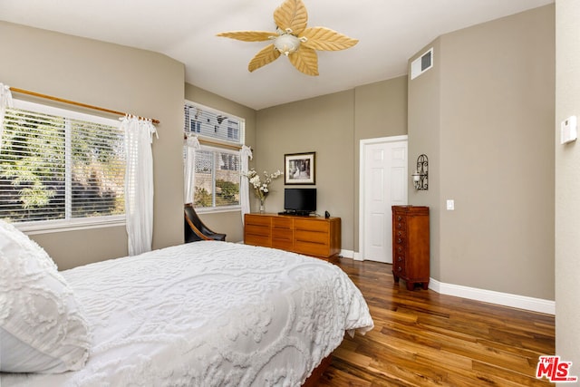 bedroom featuring ceiling fan, dark hardwood / wood-style floors, multiple windows, and lofted ceiling