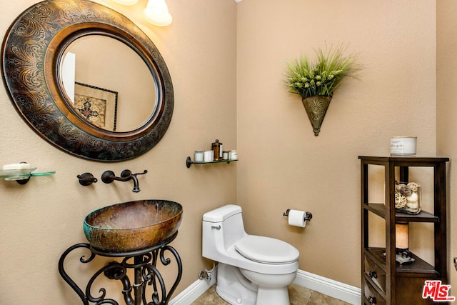 bathroom featuring sink, toilet, and tile patterned flooring