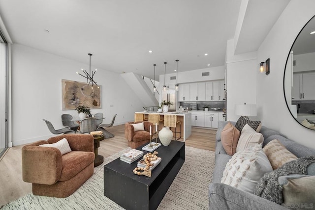 living room with a chandelier and light wood-type flooring