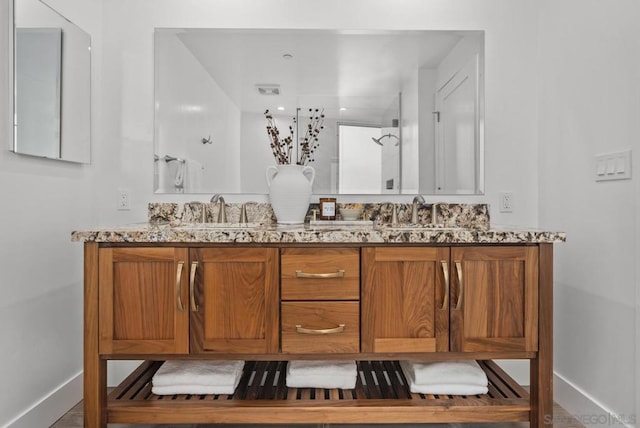 bathroom featuring walk in shower and vanity