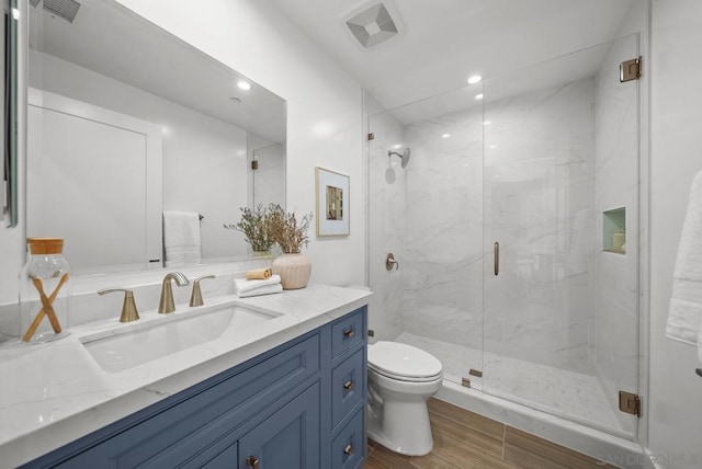 bathroom featuring vanity, hardwood / wood-style floors, toilet, and walk in shower