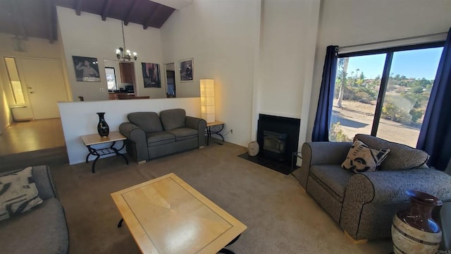 living room featuring an inviting chandelier, a wood stove, carpet floors, high vaulted ceiling, and beamed ceiling