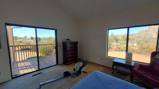 carpeted bedroom featuring vaulted ceiling, access to exterior, and a mountain view