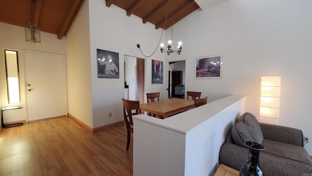 dining room with wood ceiling, beamed ceiling, an inviting chandelier, light wood-type flooring, and high vaulted ceiling