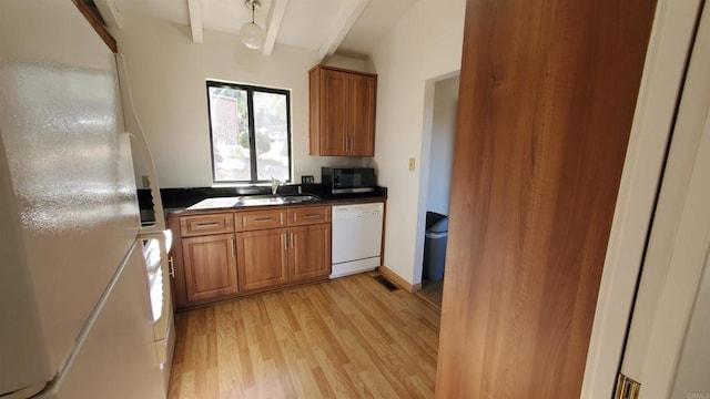 kitchen featuring light wood-type flooring, beamed ceiling, sink, and white appliances