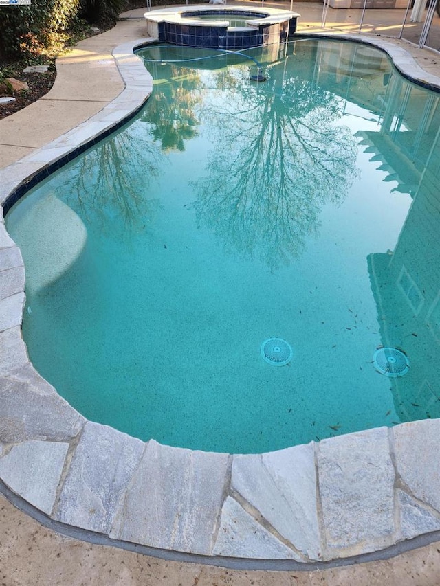 view of pool with cooling unit and an in ground hot tub