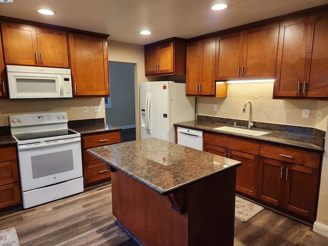 kitchen featuring sink, a center island, dark hardwood / wood-style floors, and white appliances