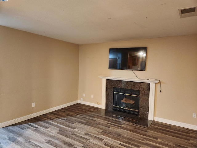 unfurnished living room featuring hardwood / wood-style floors and a premium fireplace