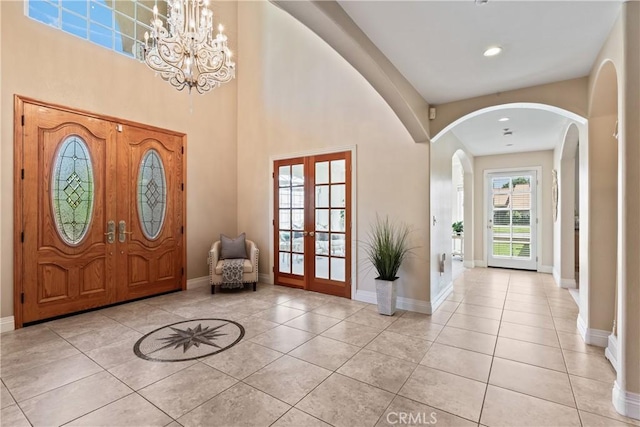 foyer featuring french doors, a notable chandelier, and light tile patterned flooring