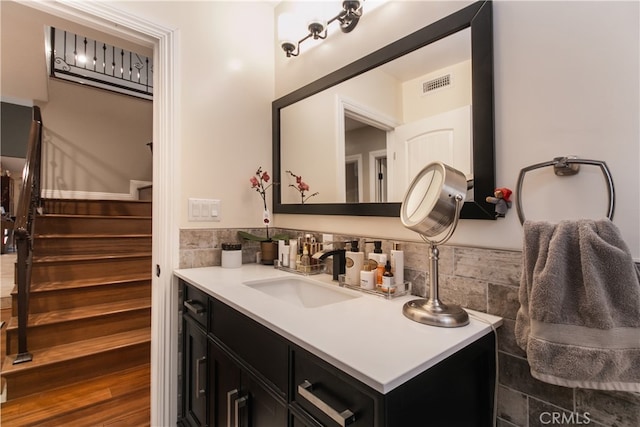 bathroom with vanity and tile walls