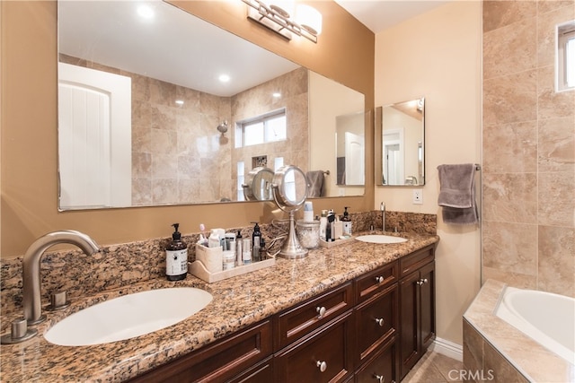 bathroom featuring vanity and tiled tub