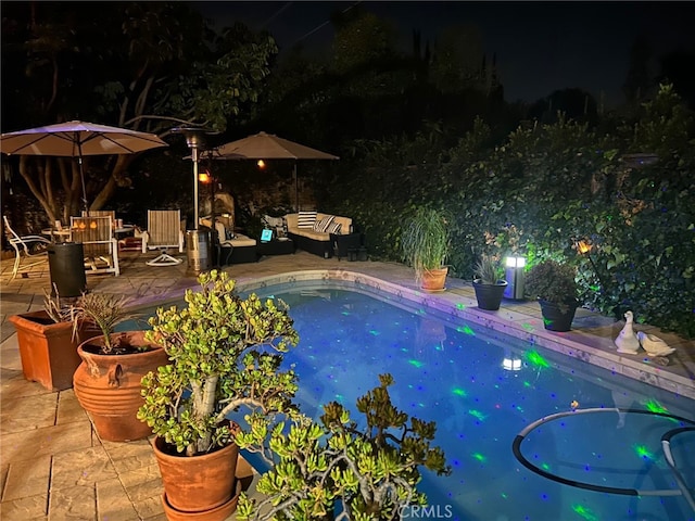 pool at twilight with a patio