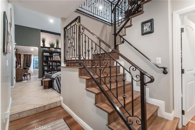 stairway featuring wood finished floors and baseboards
