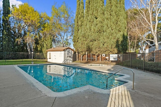 view of swimming pool featuring a patio area and a storage unit