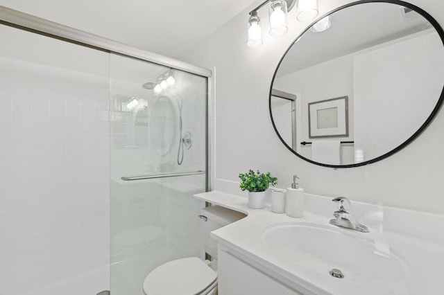 bathroom featuring toilet, vanity, and an enclosed shower