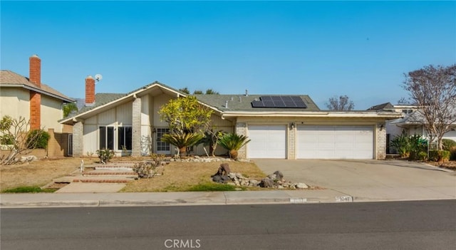 view of front of home with a garage and solar panels