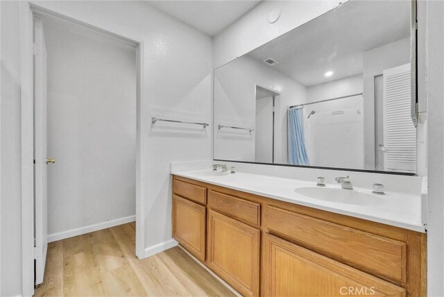 bathroom featuring hardwood / wood-style flooring, vanity, and a shower with shower curtain