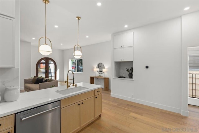 kitchen featuring light brown cabinets, decorative light fixtures, dishwasher, light hardwood / wood-style flooring, and sink