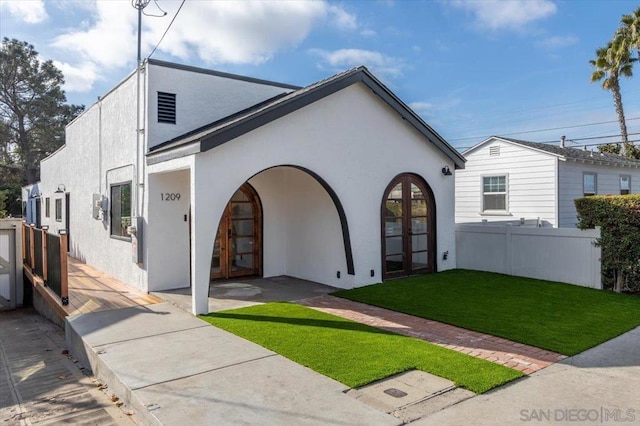 back of house with a lawn and french doors