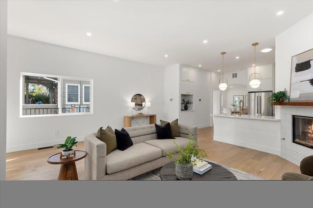 living room with sink and light hardwood / wood-style flooring