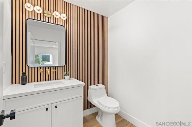 bathroom featuring toilet, vanity, and wood-type flooring