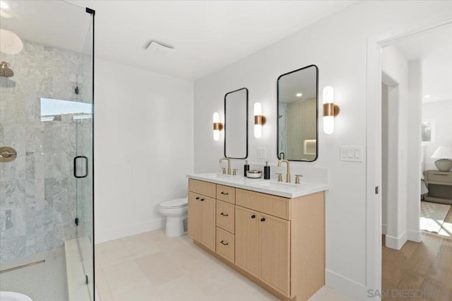 bathroom featuring toilet, a shower with door, and vanity