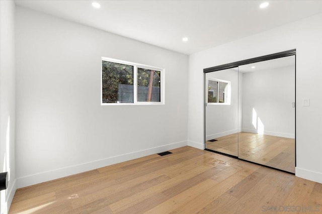 unfurnished bedroom featuring a closet and light hardwood / wood-style floors