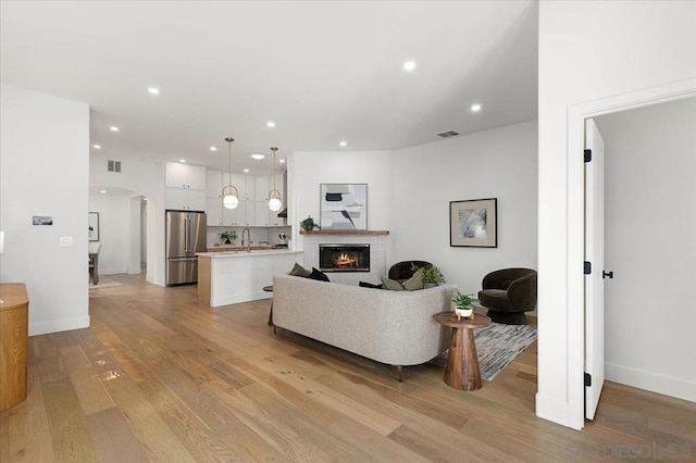 living room with sink and light hardwood / wood-style flooring