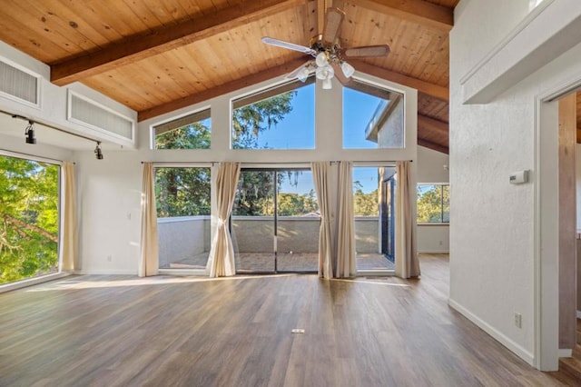 unfurnished living room with beamed ceiling, hardwood / wood-style flooring, ceiling fan, and a healthy amount of sunlight