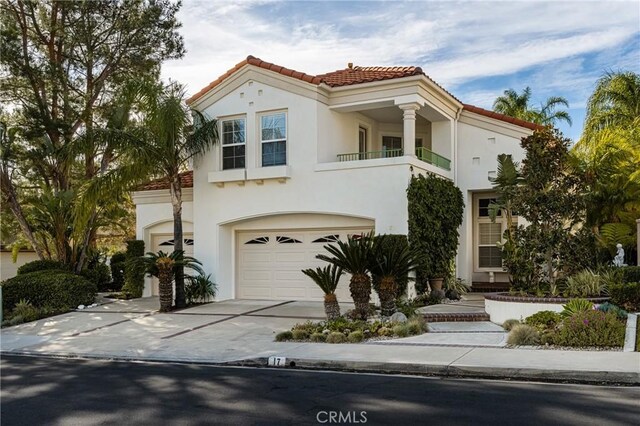 mediterranean / spanish-style home with a garage and a balcony