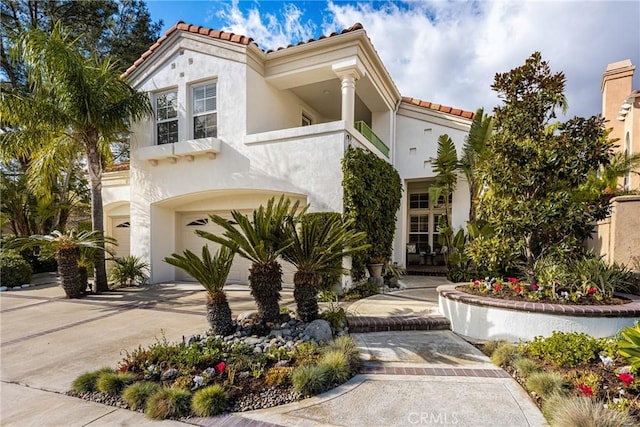 mediterranean / spanish-style house featuring a garage and a balcony