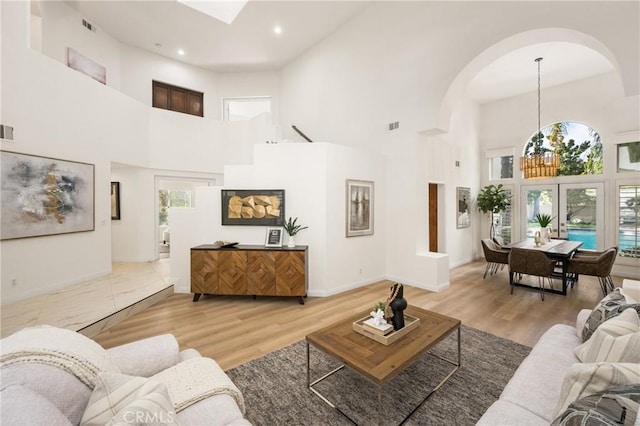 living room featuring hardwood / wood-style flooring and a towering ceiling