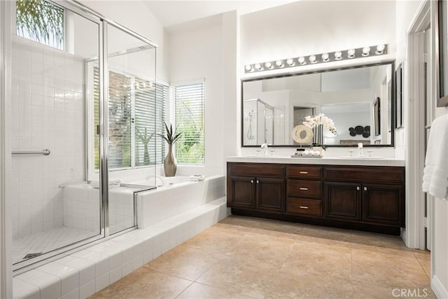 bathroom featuring independent shower and bath, vanity, and a healthy amount of sunlight