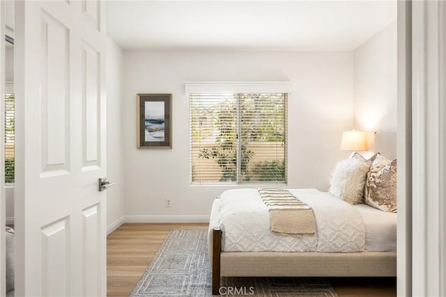 bedroom featuring multiple windows and light hardwood / wood-style floors