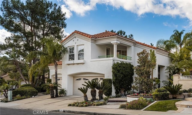 mediterranean / spanish home featuring a garage and a balcony