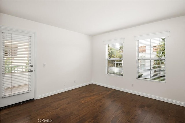 unfurnished room with dark wood-type flooring