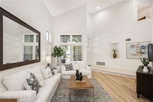 living room featuring hardwood / wood-style flooring and high vaulted ceiling