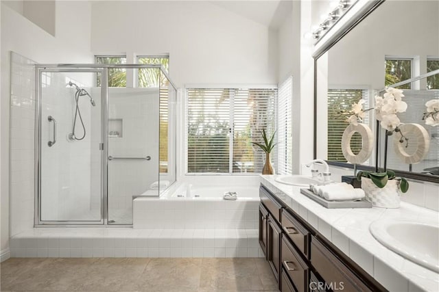 bathroom with vanity, shower with separate bathtub, and vaulted ceiling