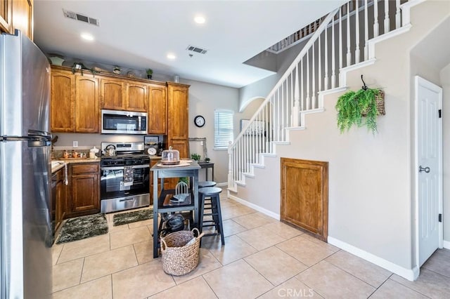 kitchen with light tile patterned floors and appliances with stainless steel finishes