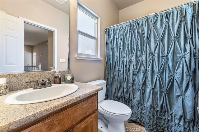 bathroom featuring toilet, a shower with shower curtain, and vanity