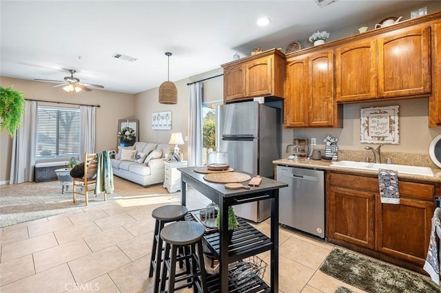 kitchen with hanging light fixtures, plenty of natural light, sink, and stainless steel appliances