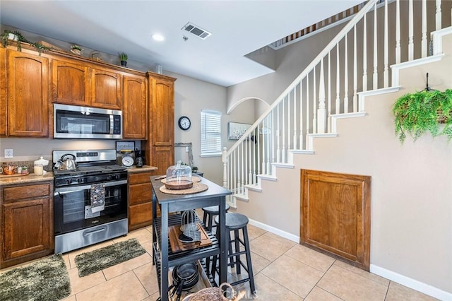 kitchen with light tile patterned floors and stainless steel appliances