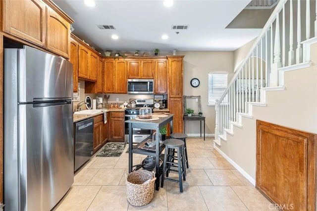 kitchen with light tile patterned floors, appliances with stainless steel finishes, and sink