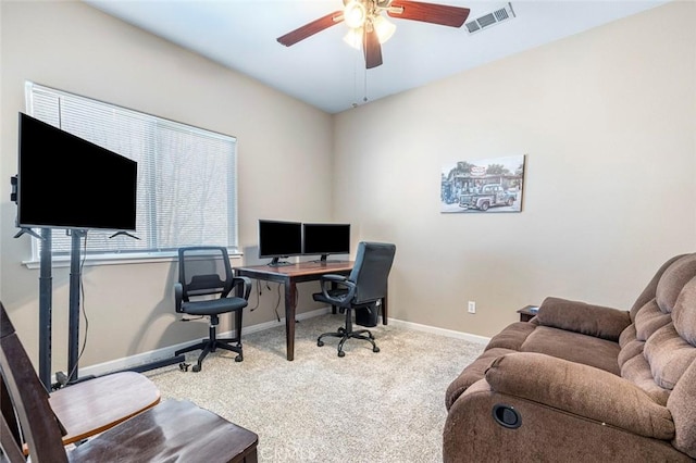 carpeted home office featuring ceiling fan