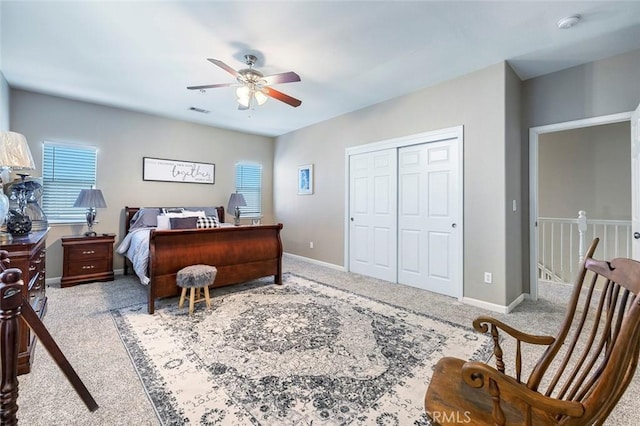 bedroom featuring ceiling fan, a closet, and light carpet