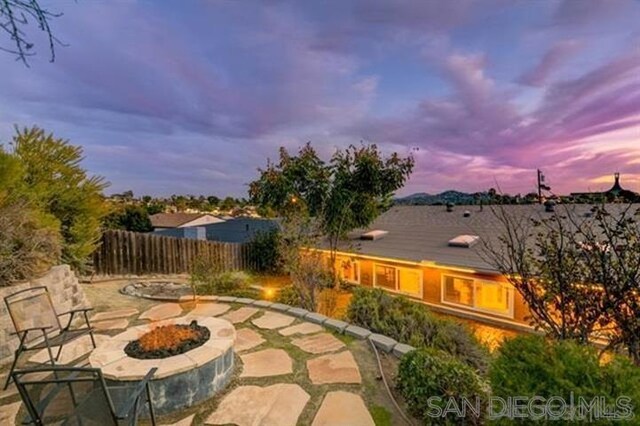 patio terrace at dusk featuring an outdoor fire pit