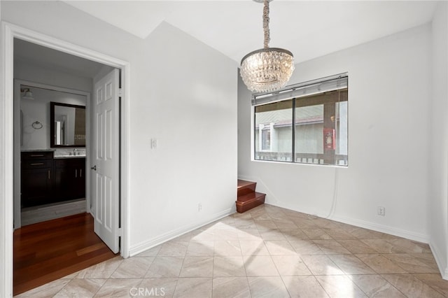 empty room featuring sink and a chandelier