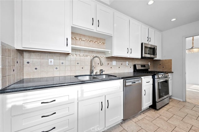 kitchen with appliances with stainless steel finishes, white cabinetry, tasteful backsplash, and sink